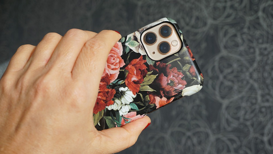 An iPhone 11 Pro with a flower back case